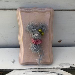 Crocheted tiny mouse on a wood plaque